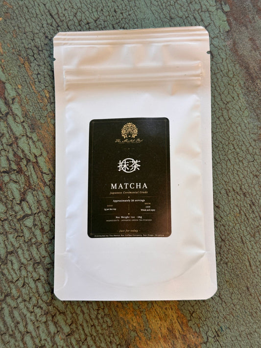 The Mental Bar ceremonial grade matcha pouch, 1oz, flat lay on teal green concrete surface